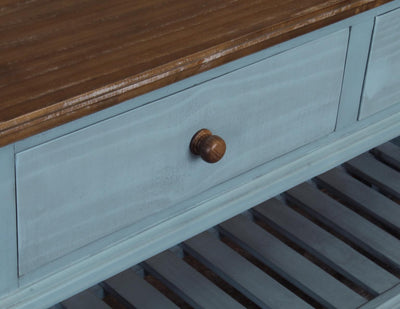 Close-up of a wooden drawer with a blue frame and a wooden top.